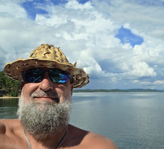 Heath Ledet enjoying time on the water with a scenic lake view.