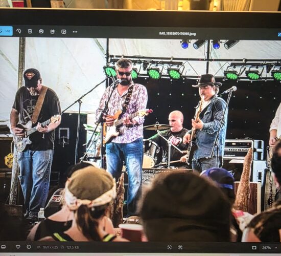 Heath Ledet playing electric guitar with a live band on stage.