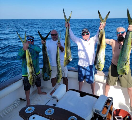 Heath Ledet holding freshly caught fish with friends on a fishing boat.